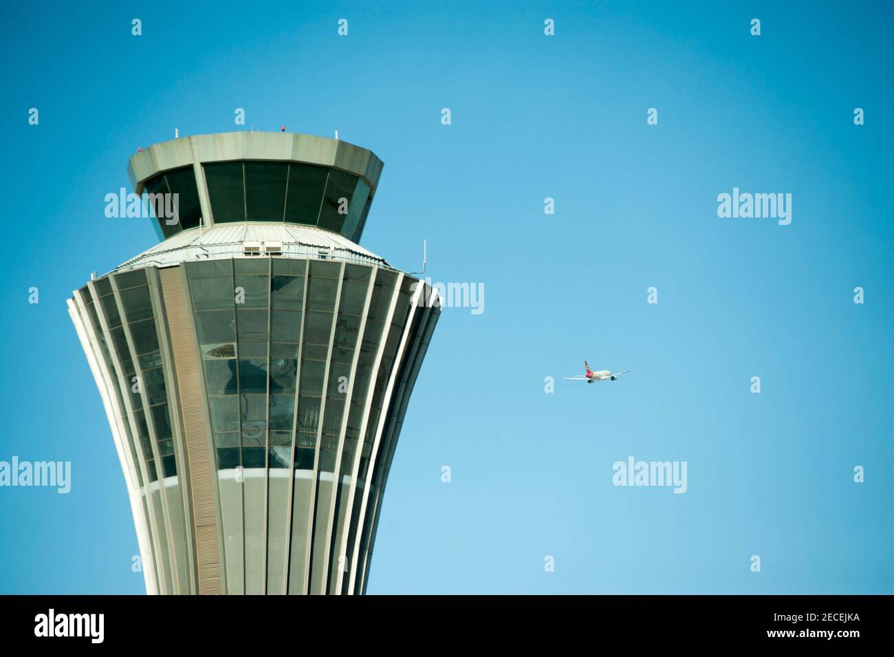 A Shenzhen Airlines aircraft flies past the Air traffic Control tower on departure on a sunny, blue sky, pollution-free day at Beijing Capital Airport, in the Shunyi district of the Chinese capital, Beijing, China, PRC. © Time-Snaps Stock Photo