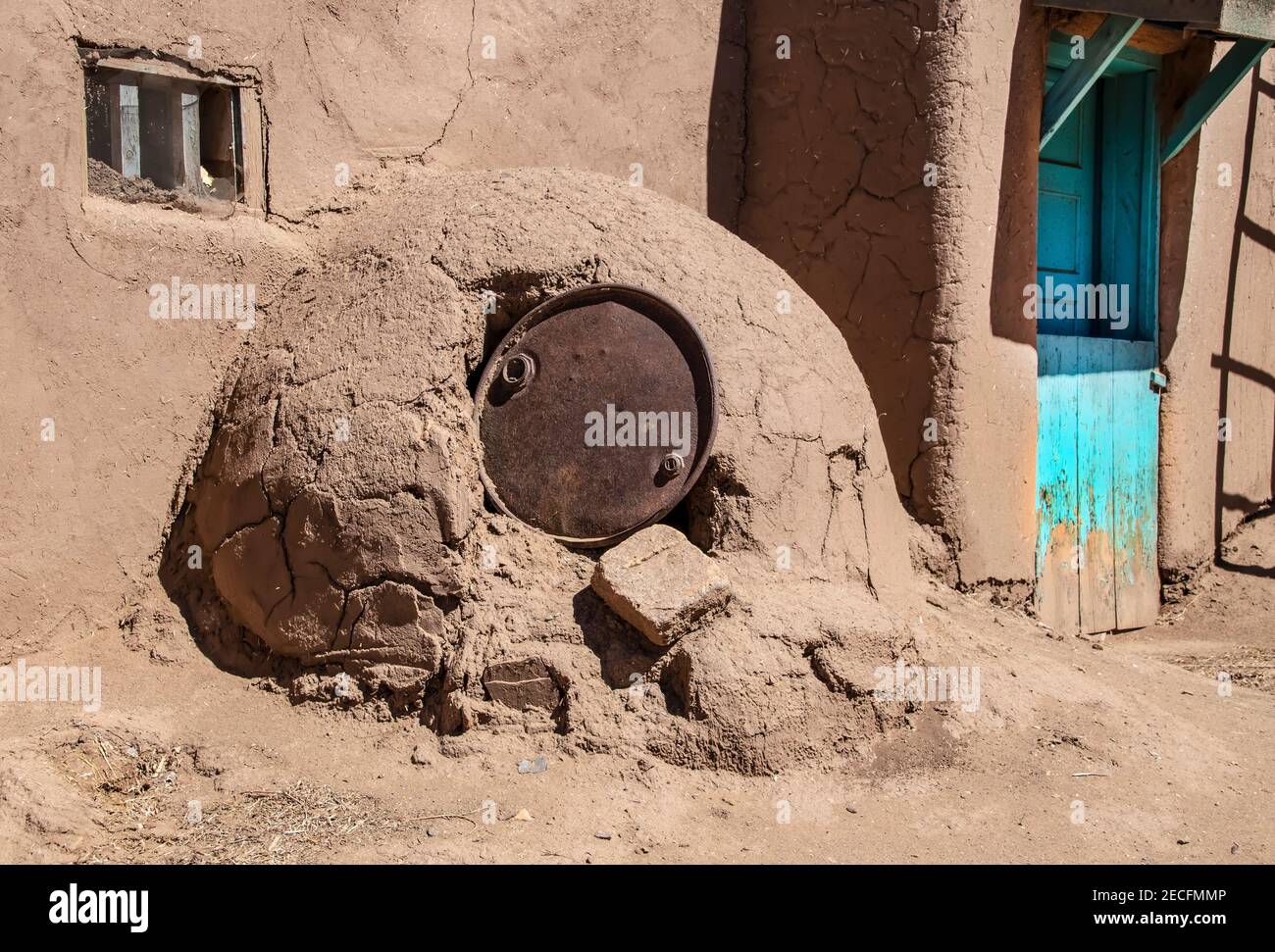 Horno - mud adobe outdoor oven in Southwestern US Pueblo community with old metal barrel top protecting the opening - common in all Spanish-occupied l Stock Photo