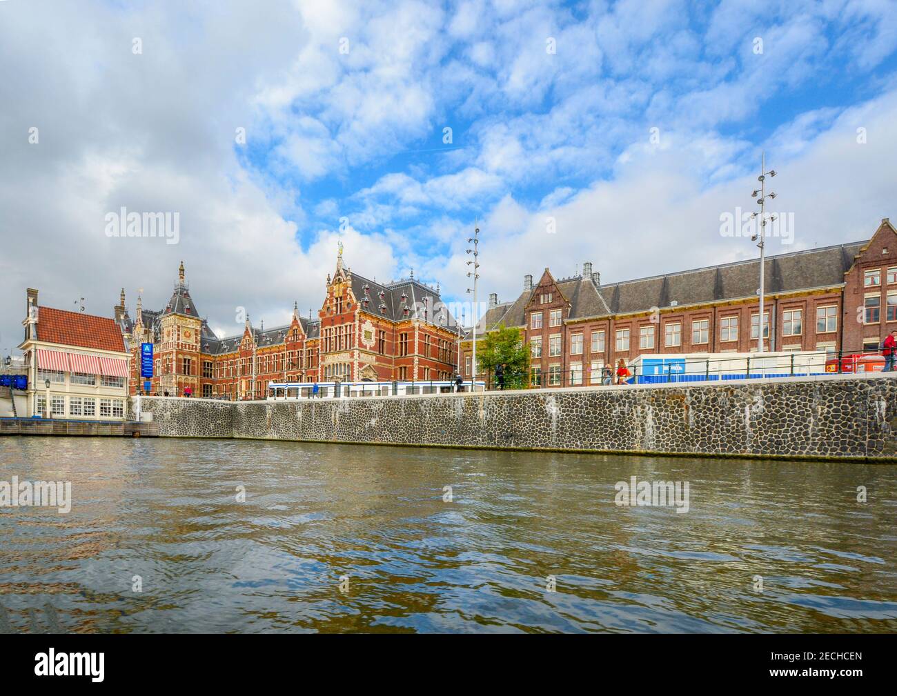 The Amsterdam Centraal Train or Railway station seen from a boat on a canal. Stock Photo