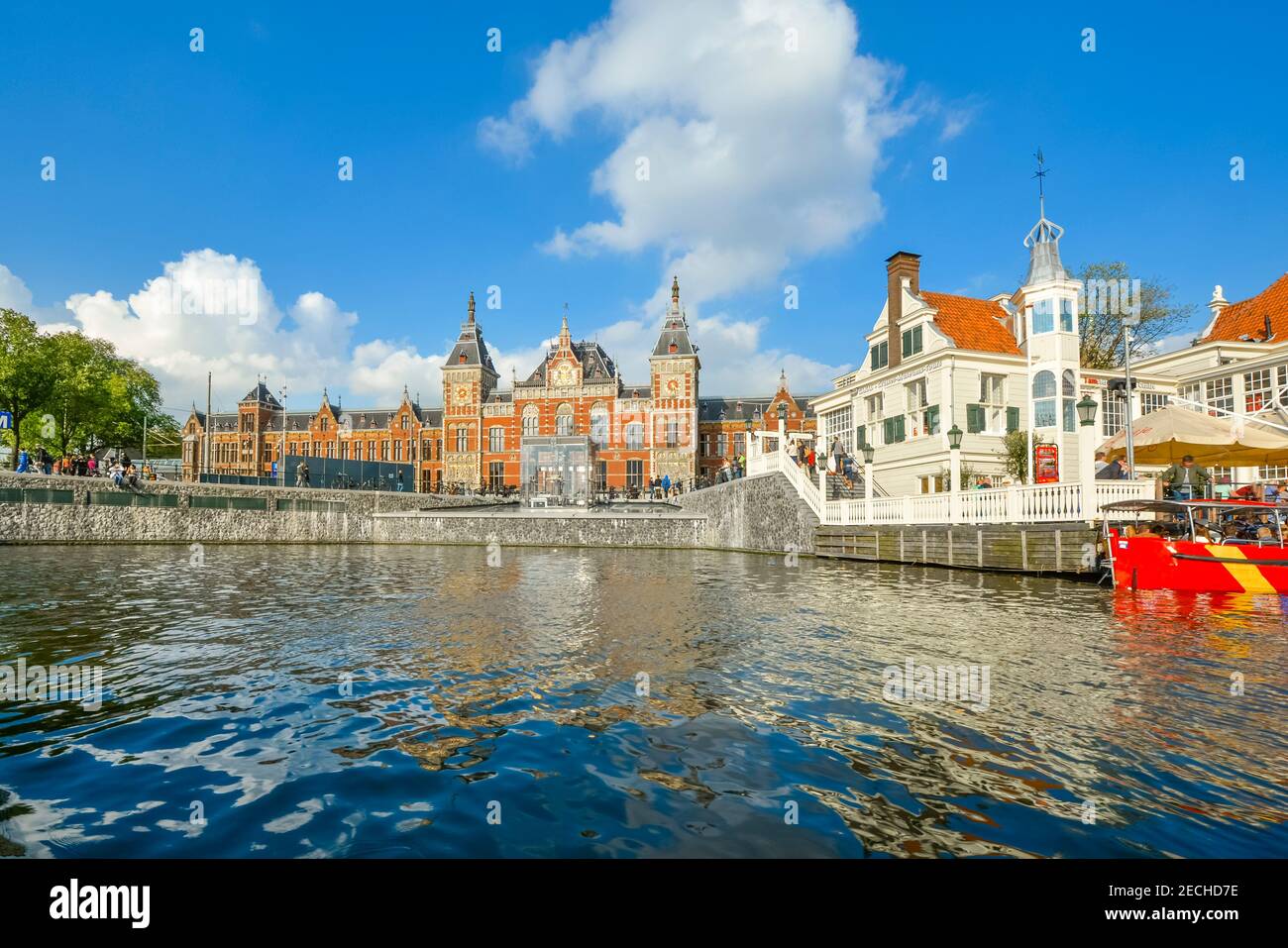 Canal view of Amsterdam Centraal, the largest railway station of Amsterdam, Netherlands, and a major railway hub Stock Photo