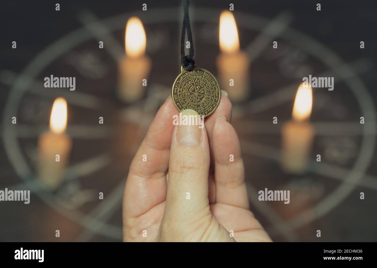 amulet of predictions in hand on the background of the magic circle.  Stock Photo
