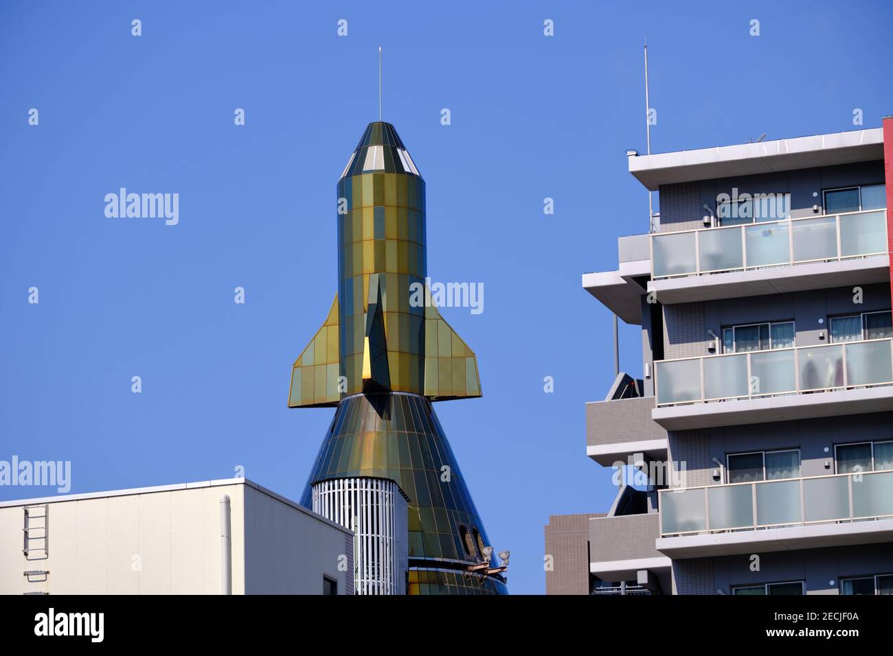 The Omiya Rocket Building, viewed of the top as seen between more regular buildings in Saitama Japan Stock Photo