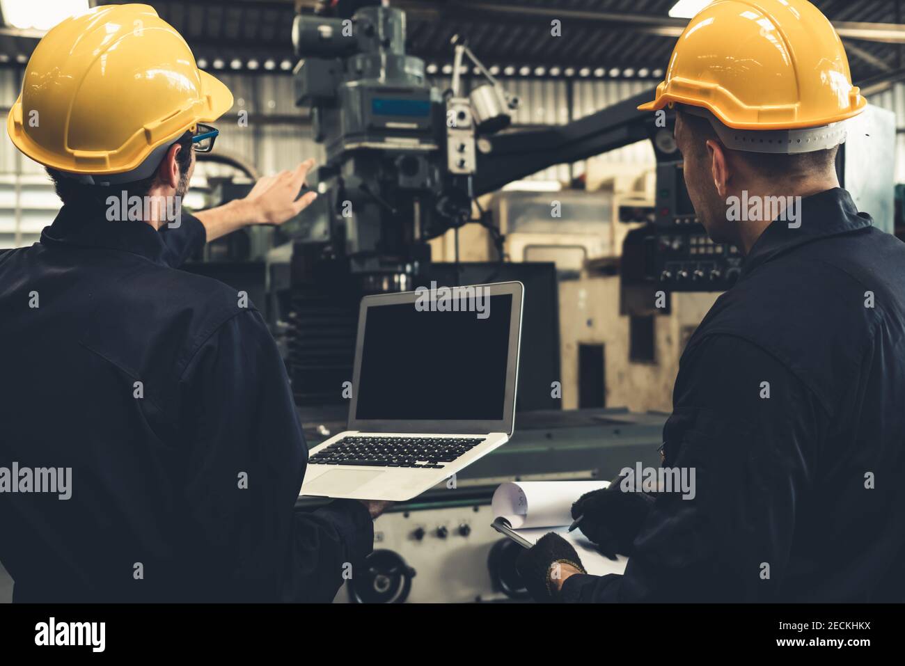 Skillful factory worker working with laptop computer to do procedure