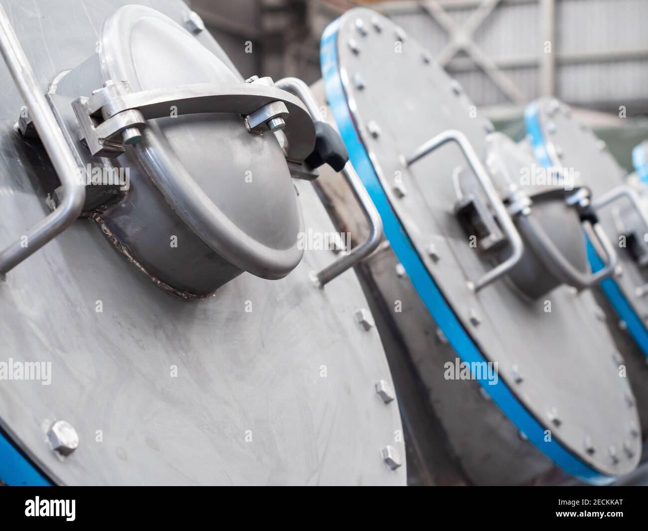 Circular hatches of a stainless steel industrial vacuum dryer. Shallow ...