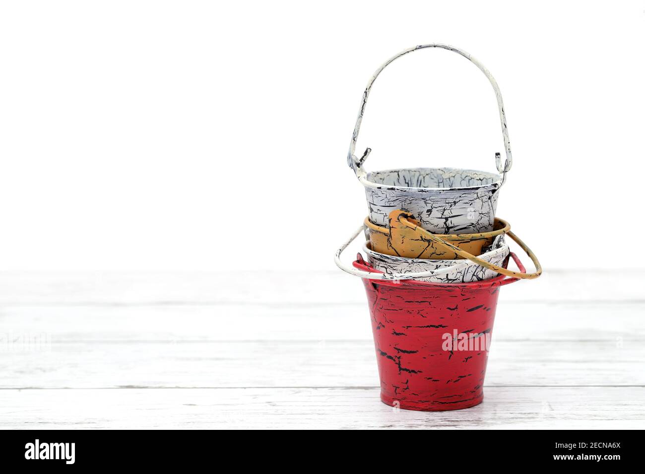 Empty miniature metal bucket on white wooden table Stock Photo