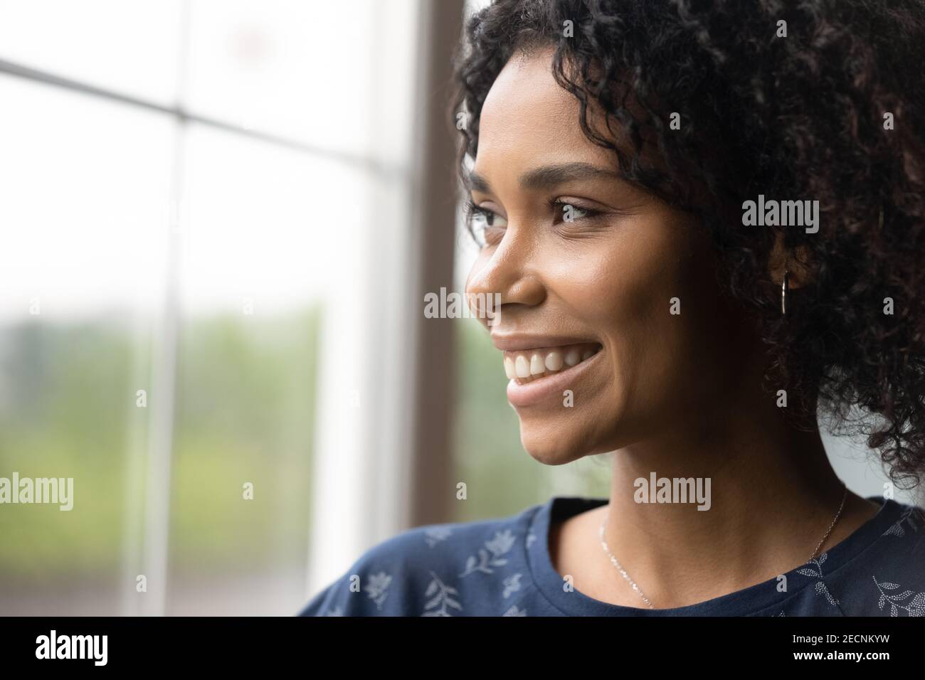 Close Up Dreamy Smiling African American Woman Looking Out Window 