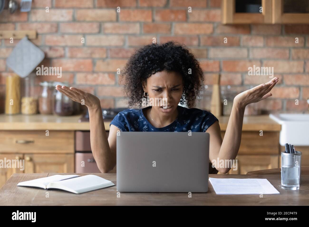 Close up unhappy irritated African American woman using laptop Stock Photo
