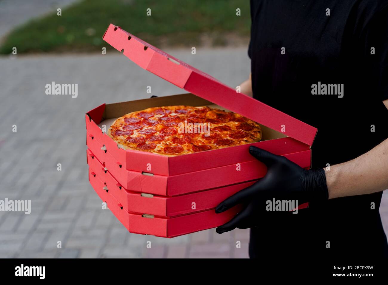 Safety pizza delivery from restaurant. Food courier in black medical ...