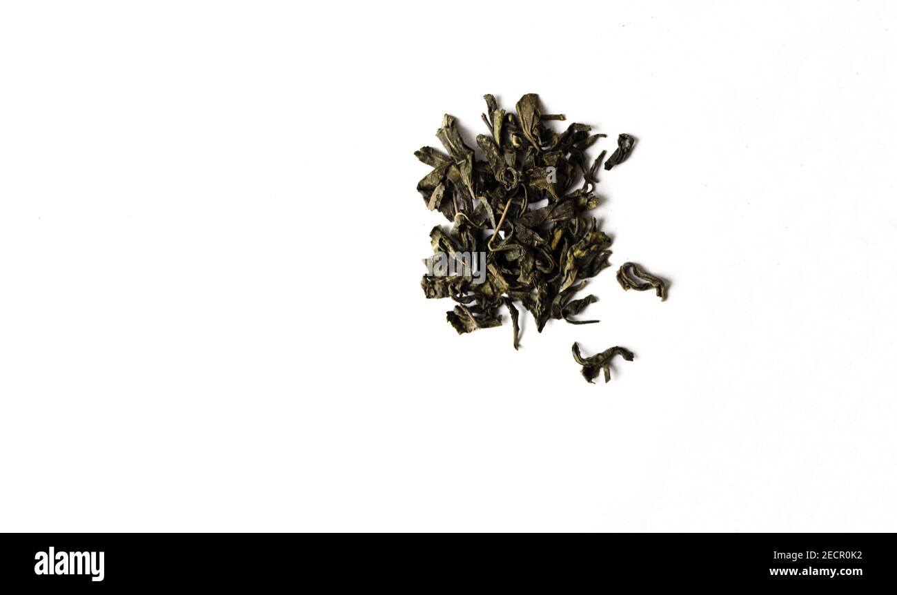 Black tea leaves on white isolated background.Black dry tea leaves. Stock Photo