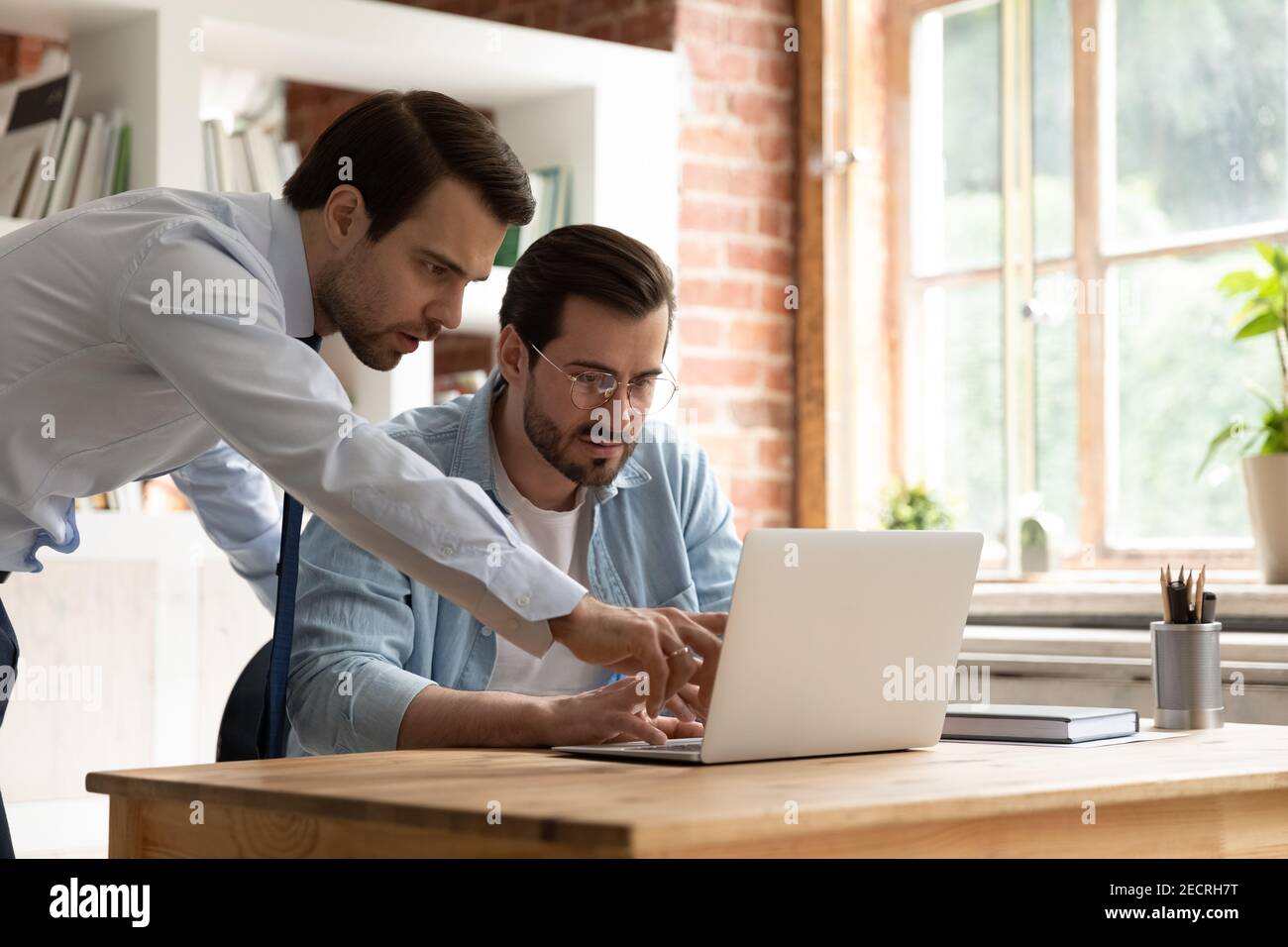 Male employees brainstorm work together on laptop Stock Photo