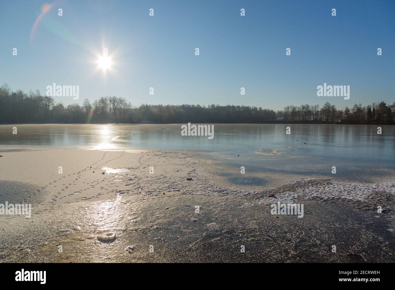 Aufgehende Sonne im Gegenlicht an der zugefrorenen Grube Fernie in Großen-Linden bei Gießen, Hessen, Deutschland im Februar 2021 Stock Photo