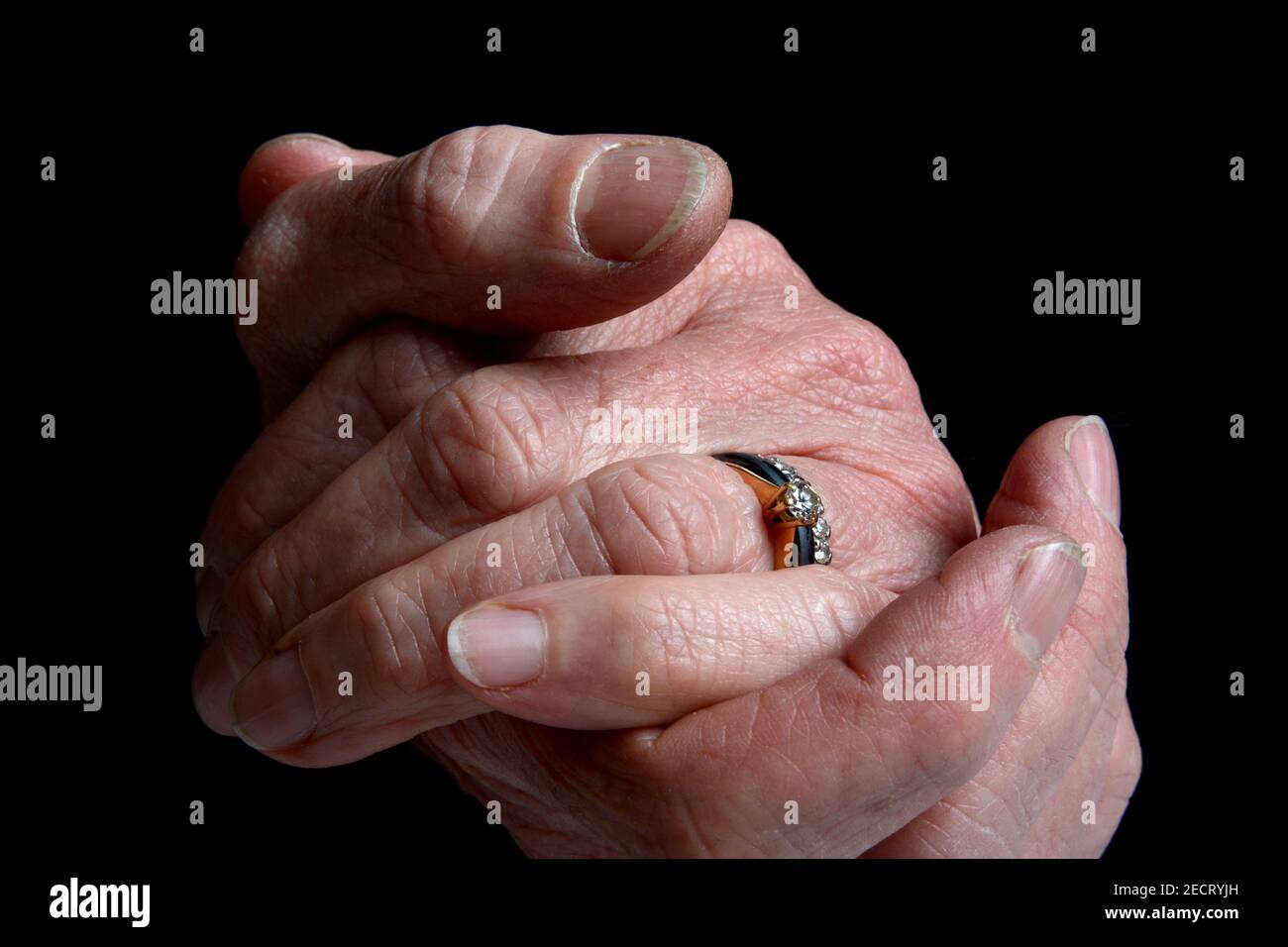 Hands clasped together showing intimacy and connection with a ring on ...