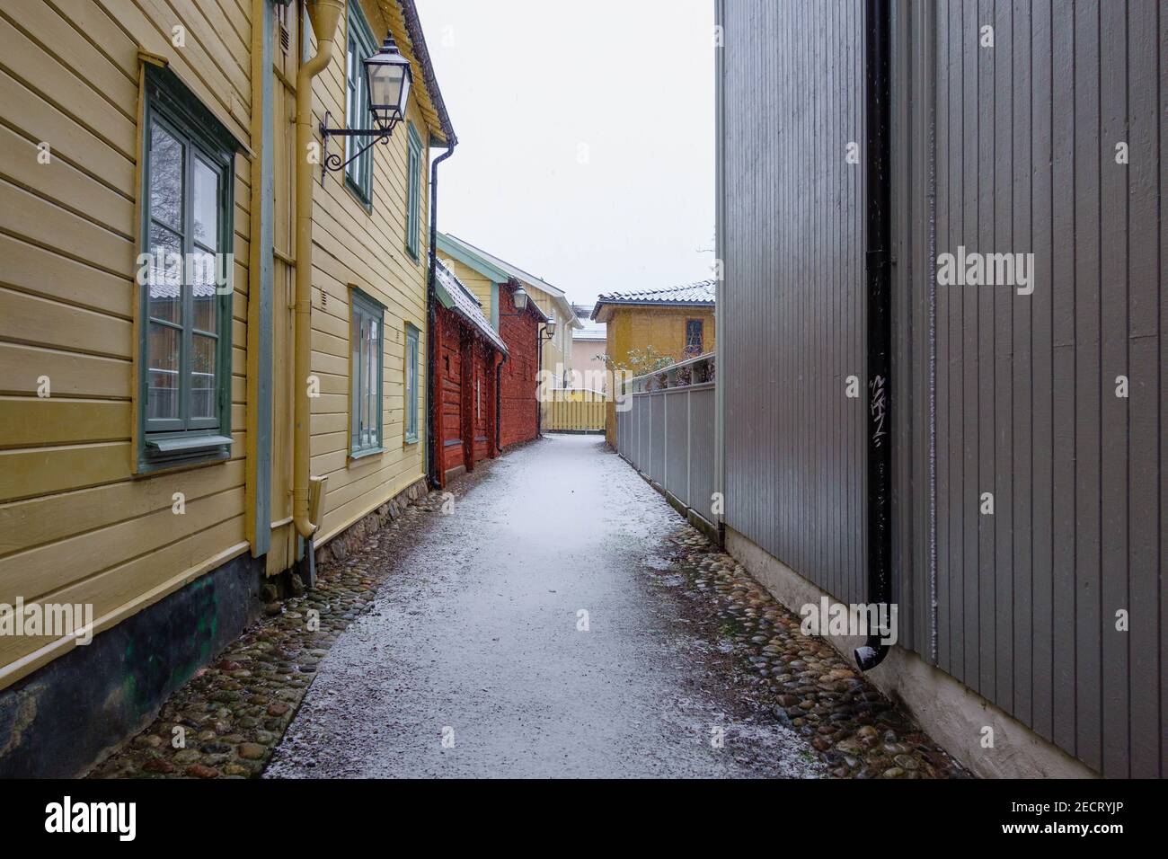 The snow falls over the narrow alley in the Old Town in Eskilstuna Stock Photo