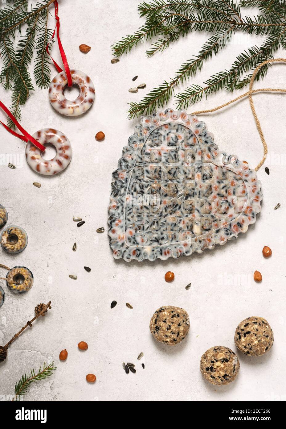 Heart shaped bird feeder made with peanuts, sunflower seeds, coconut fat  and tit dumplings, bundt, donut suit cakes Stock Photo - Alamy, image size:928x1390