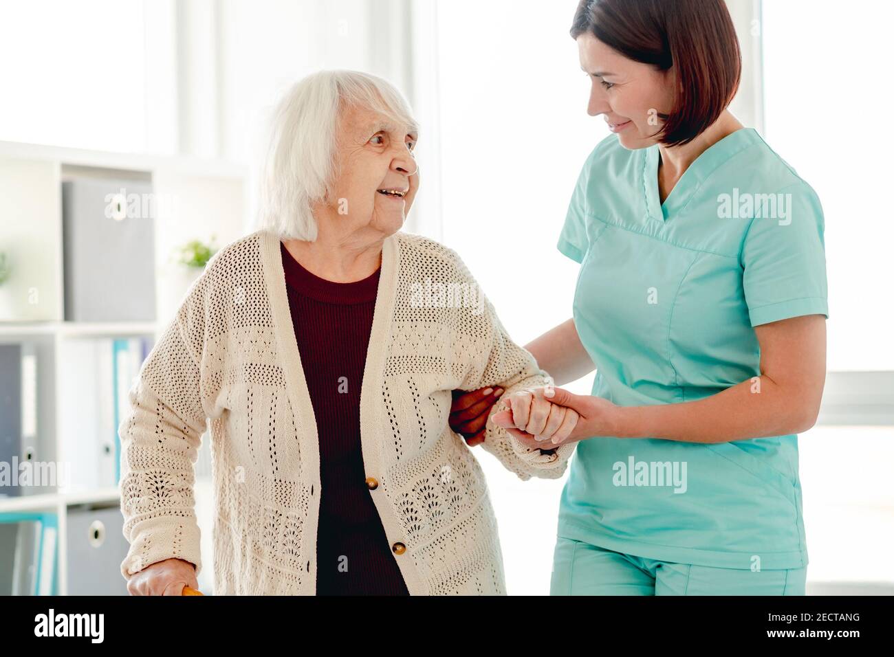 Caregiver helping elderly woman to walk Stock Photo Alamy