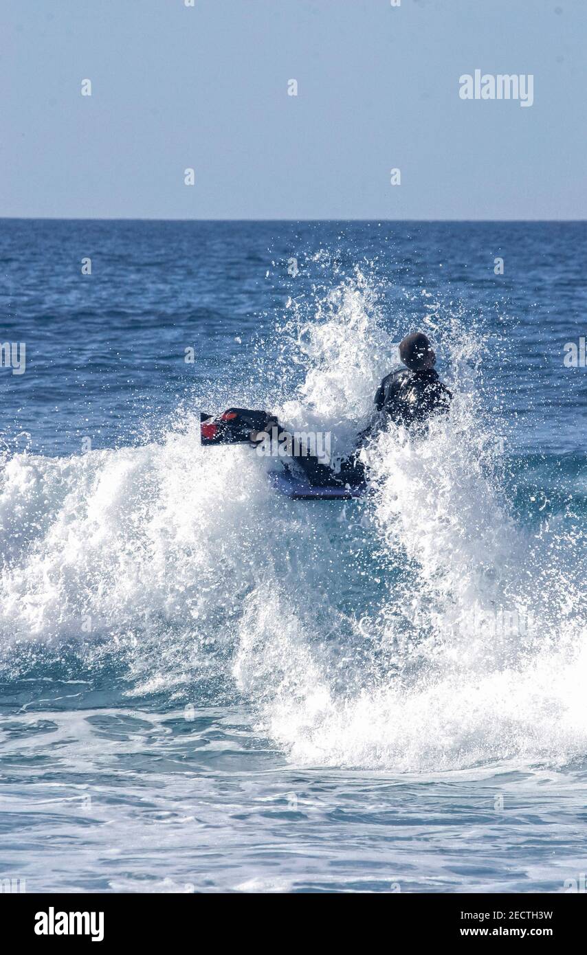 A water sportsman on his body-board turning on the top of a wave on a beach in France Stock Photo