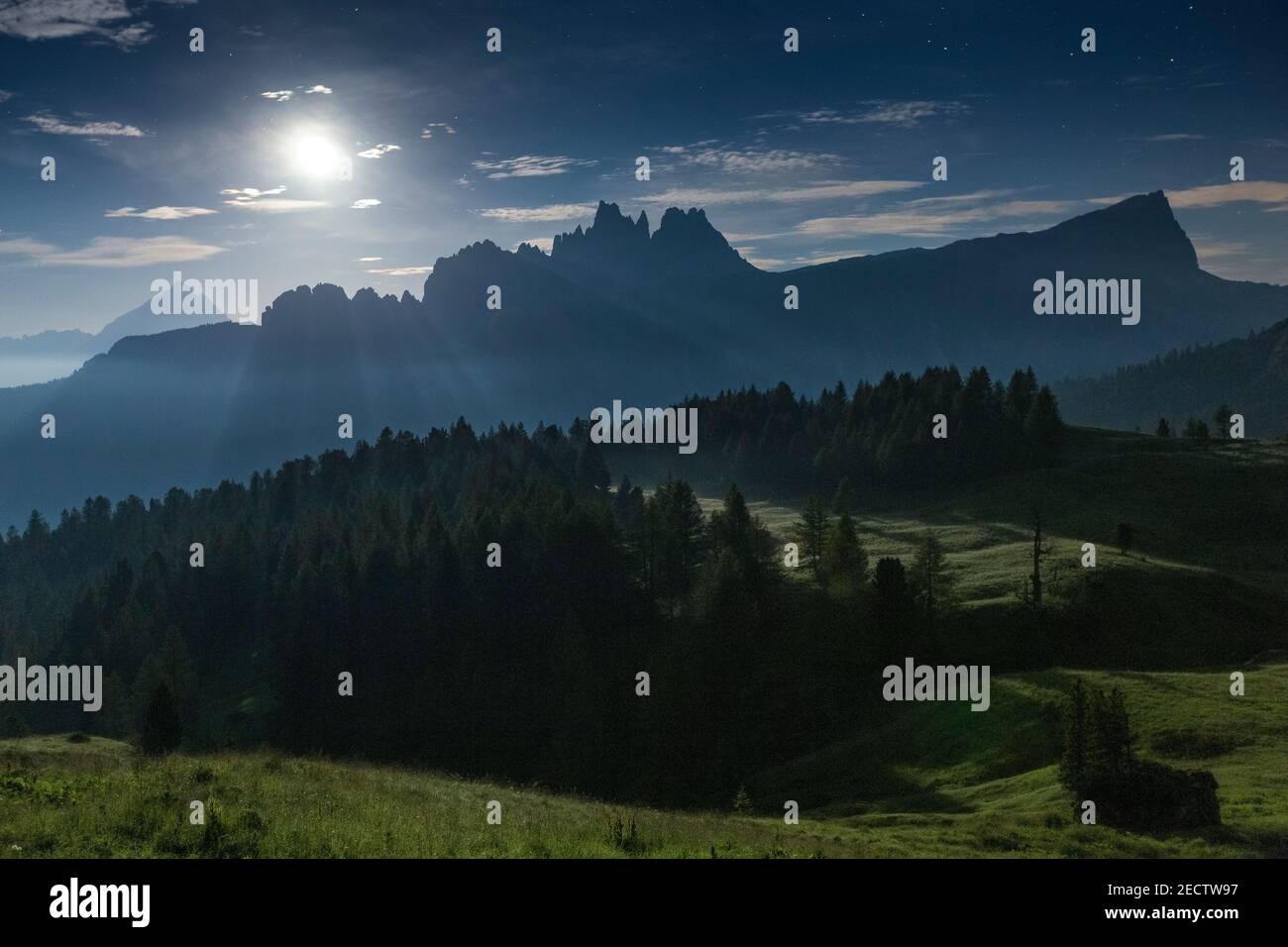 Moonlight on the Croda da Lago and Lastoni di Formin mountain peaks. Night landscape. The Ampezzo Dolomites. Coniferous forest. Italian Alps. Europe. Stock Photo