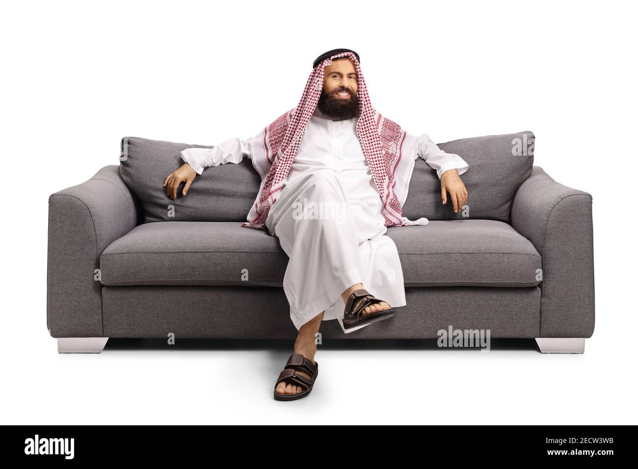Saudi arab man resting on a gray sofa isolated on white background Stock Photo