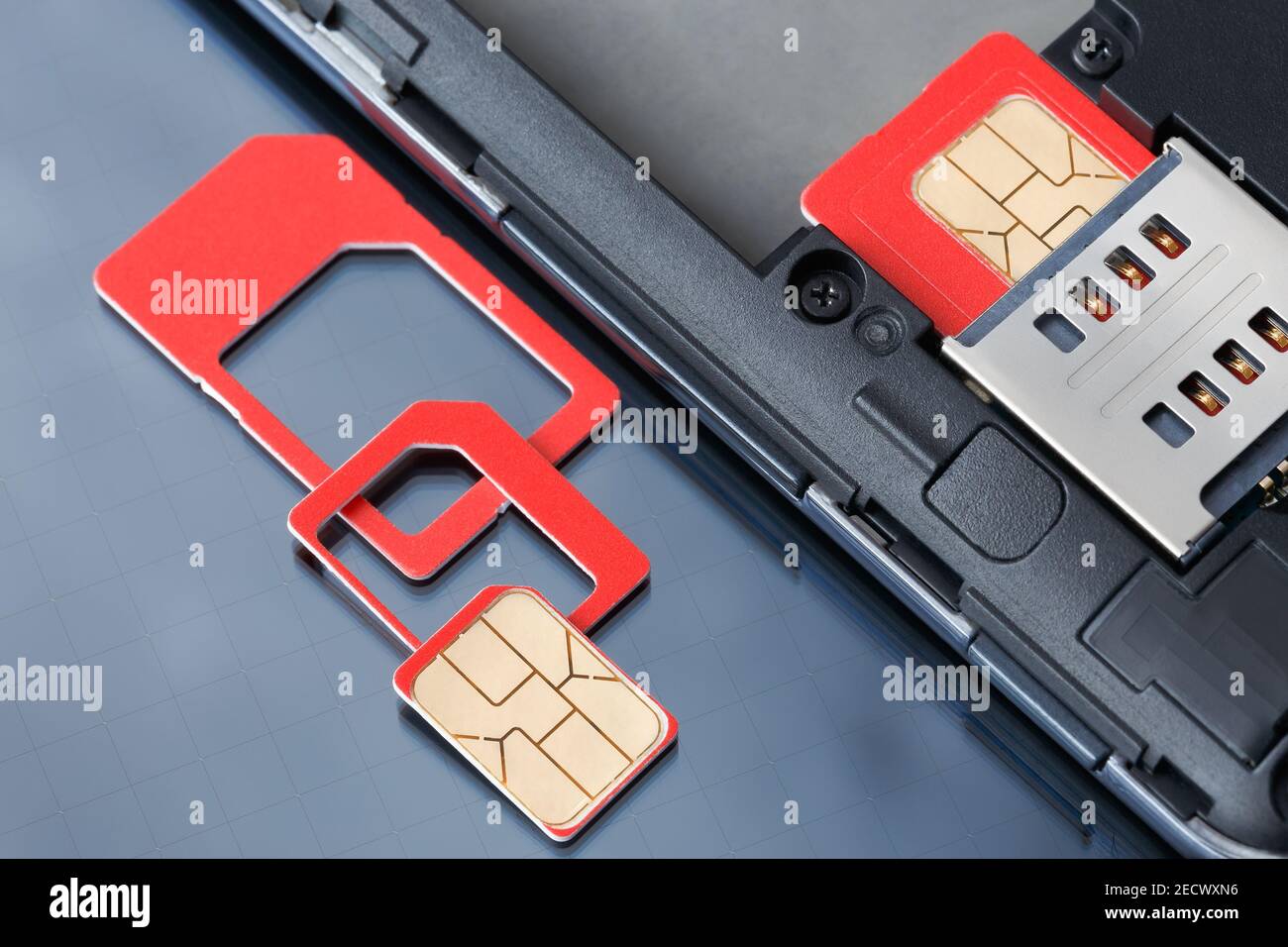 Cell phone with inserted SIM card and SIM card with frames of various sizes. Stock Photo