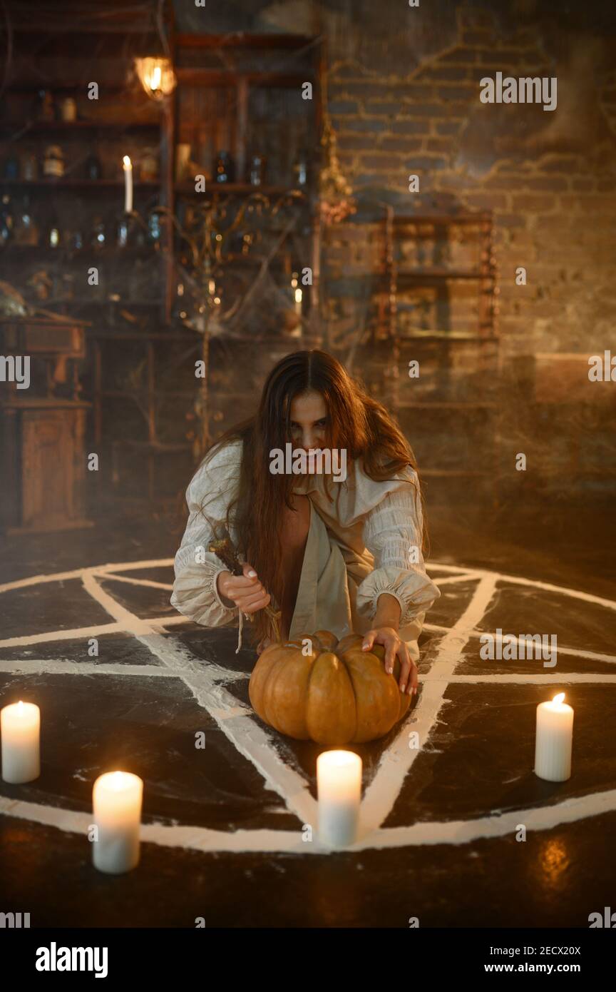 Crazy woman with pumpkin sitting in magic circle Stock Photo