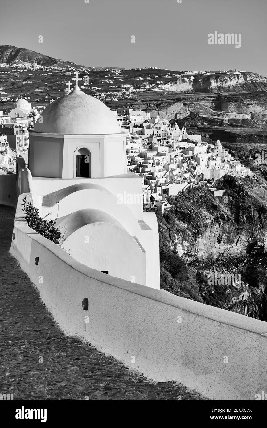 Small greek churc in Fira town on mountain coast of Santorini island in Greece. Black and white photography, landscape Stock Photo