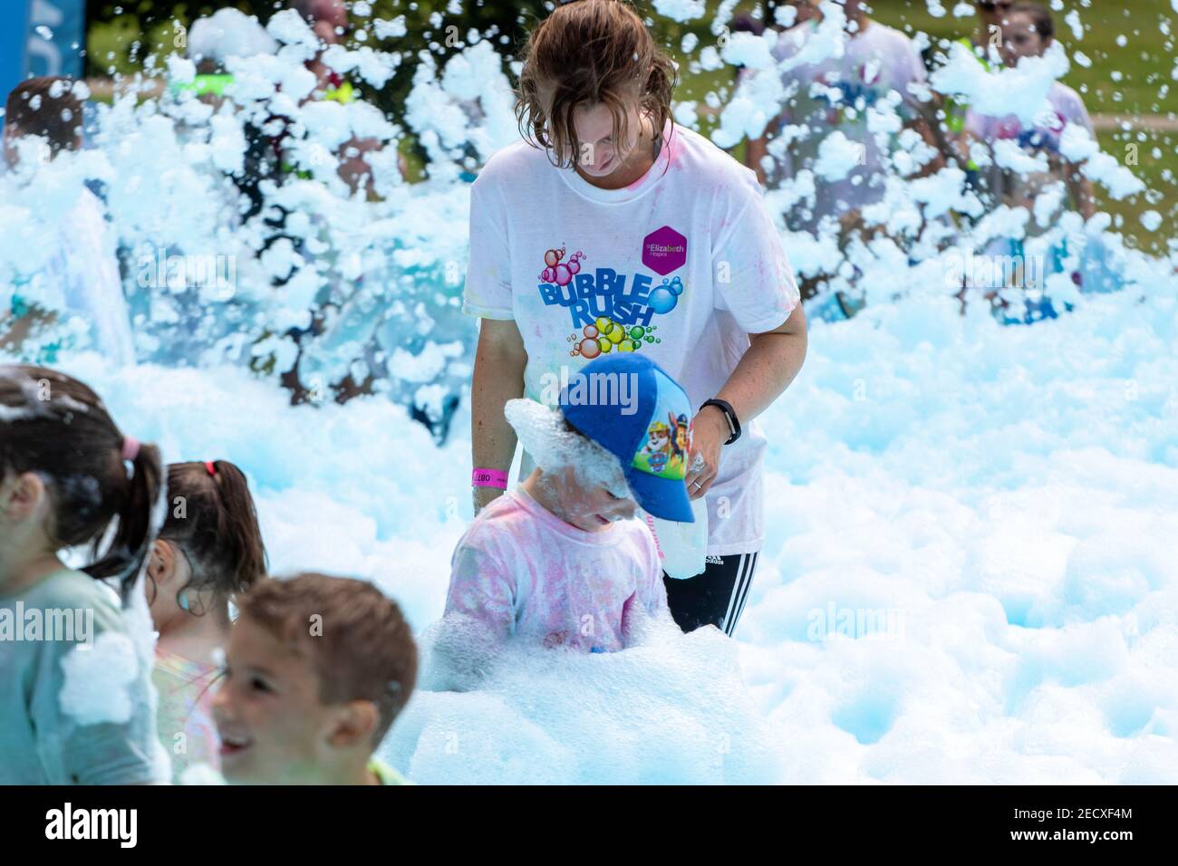 Mother watches child at a charity foam event Stock Photo Alamy