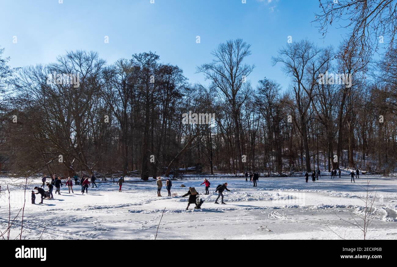 Ice skating in winter sunshine on frozen lake in Tiergarten park in Berlin Stock Photo