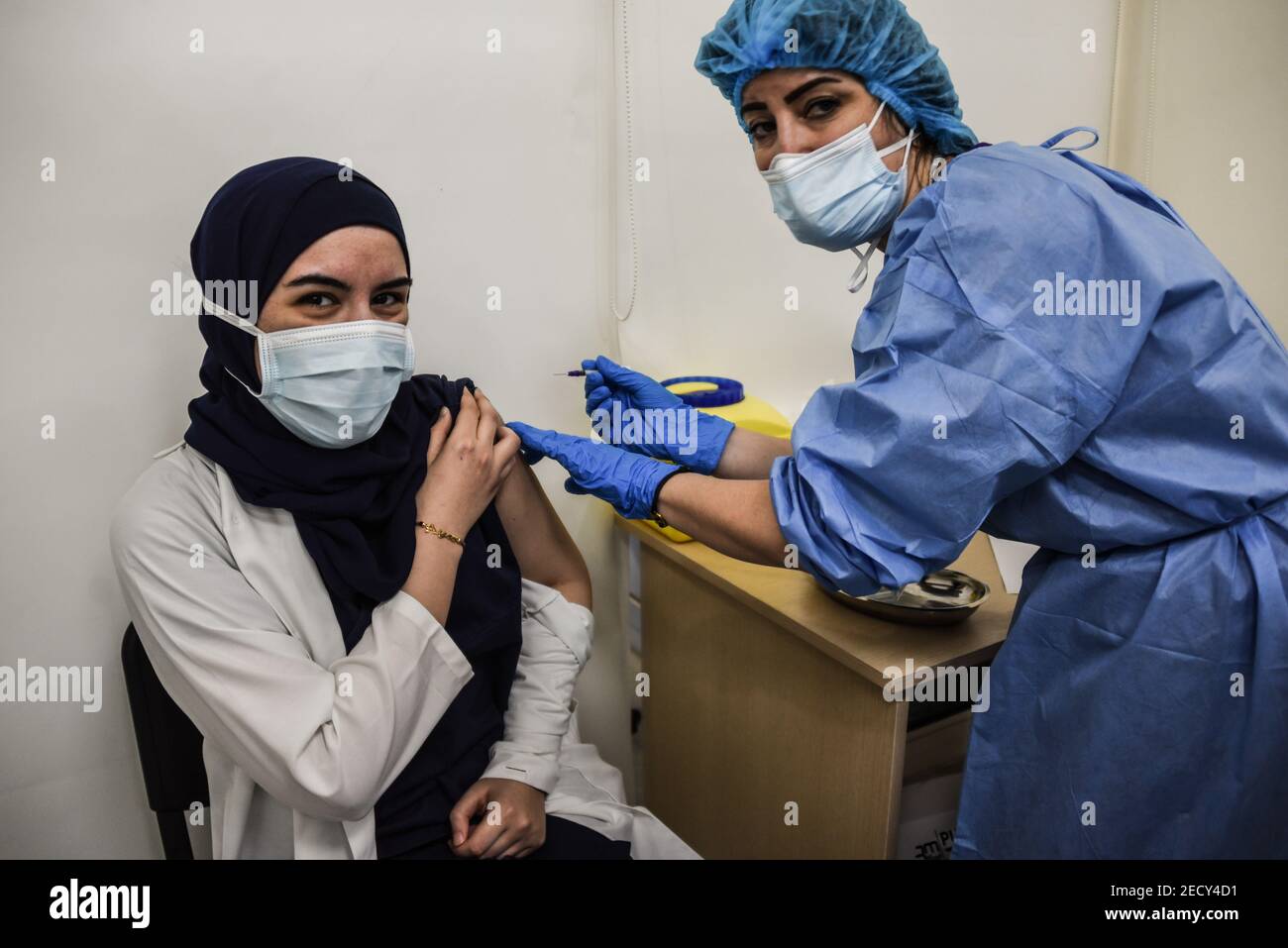 Beirut, Lebanon, 14 February, 2021. Healthcare staff receiving some of Lebanons first Covid-19 vaccines as the country begins its vaccination program with 28 thousand doses of the Pfizer-Biontech vaccine. Elizabeth Fitt Credit: Elizabeth Fitt/Alamy Live News Stock Photo