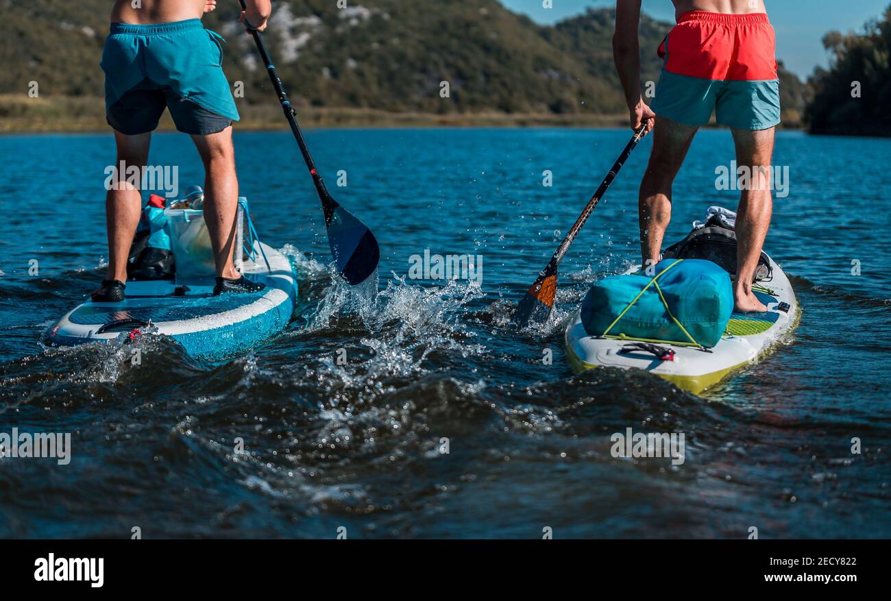 Two young athletic men competing with a SUP standing paddleboard on a ...