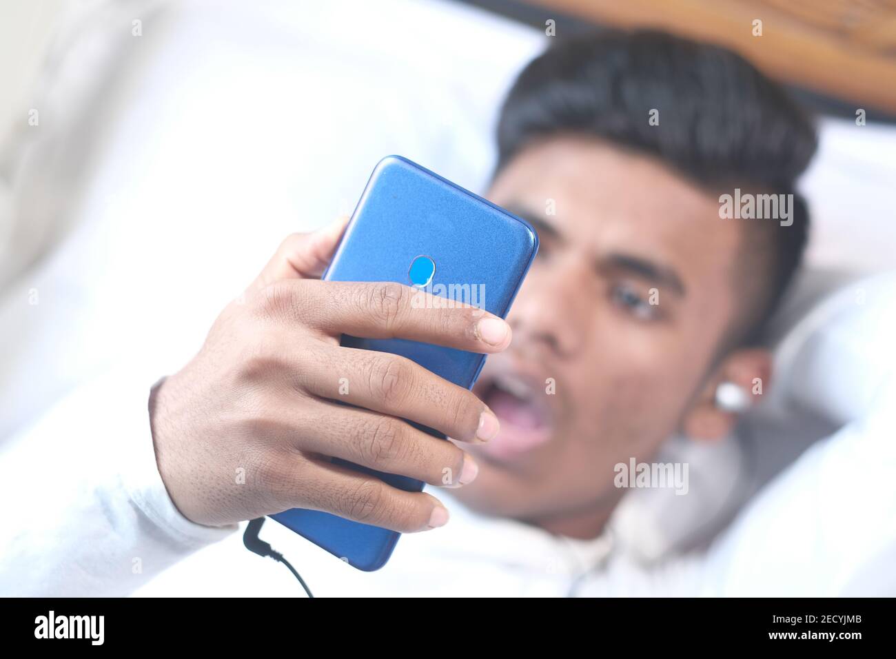 young man on bed using smart phone at night  Stock Photo