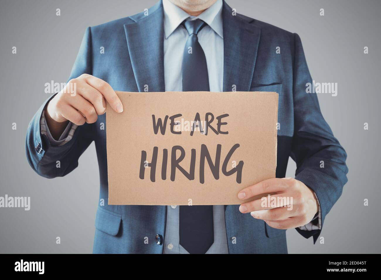 Man holds up a sign that reads 'We are hiring'. Looking for a job, employment concept Stock Photo