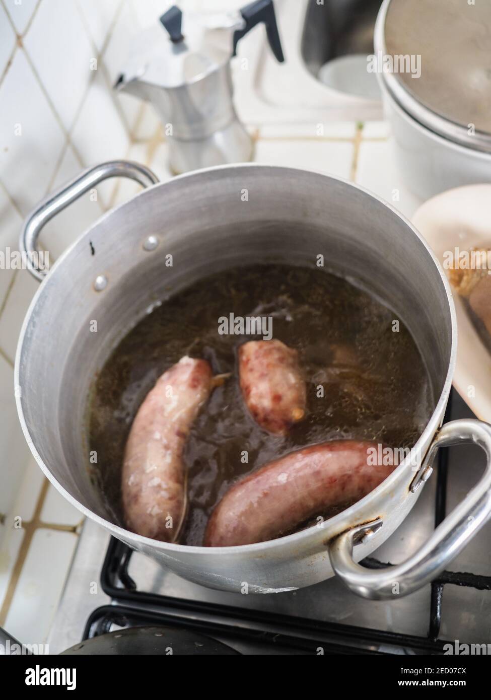 cooking boiling pork sausages in winter at home Stock Photo Alamy