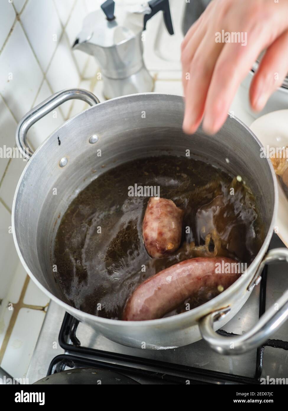 cooking boiling pork sausages in winter at home Stock Photo Alamy