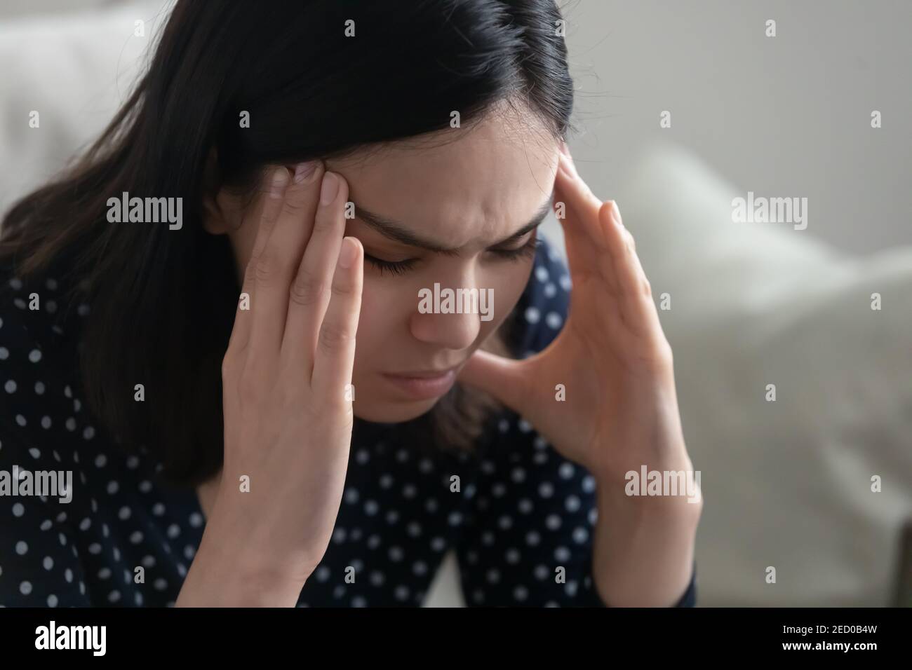 Young asian female sit alone rub temples having headache migraine Stock Photo