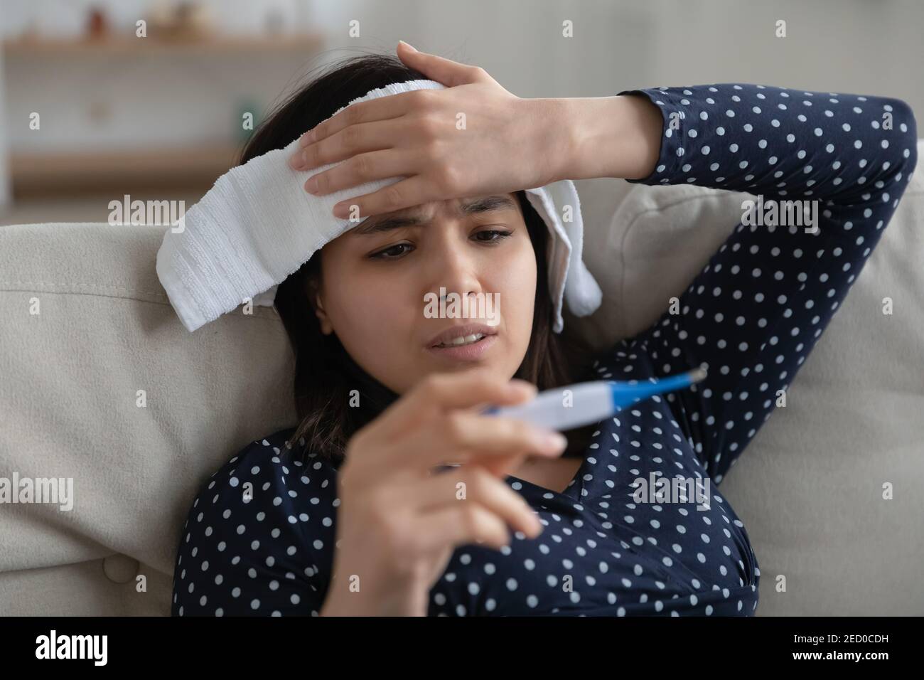 Sick asian female feel bad hold wet towel on forehead Stock Photo
