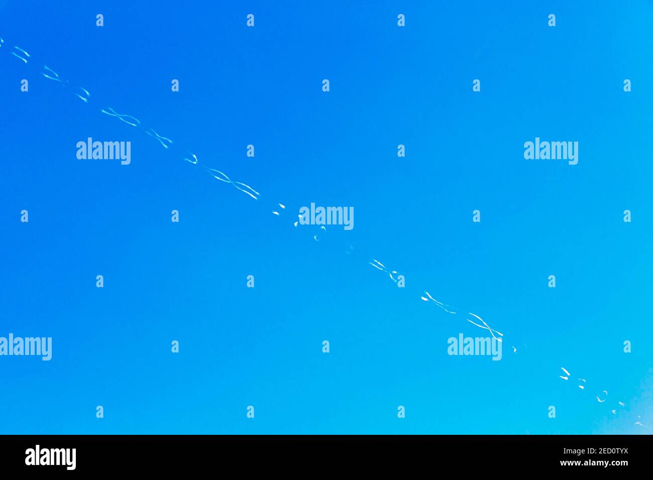 Contrails form patterns in blue sky, Santorini, Greece Stock Photo - Alamy