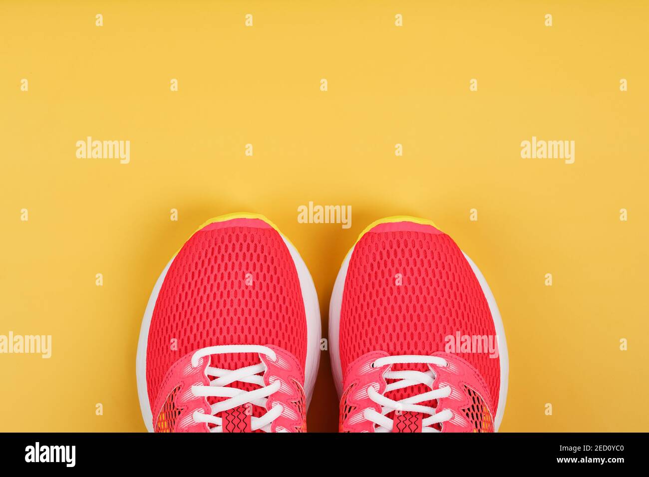Sports sneakers, pink on a yellow background with free space. Top view ...
