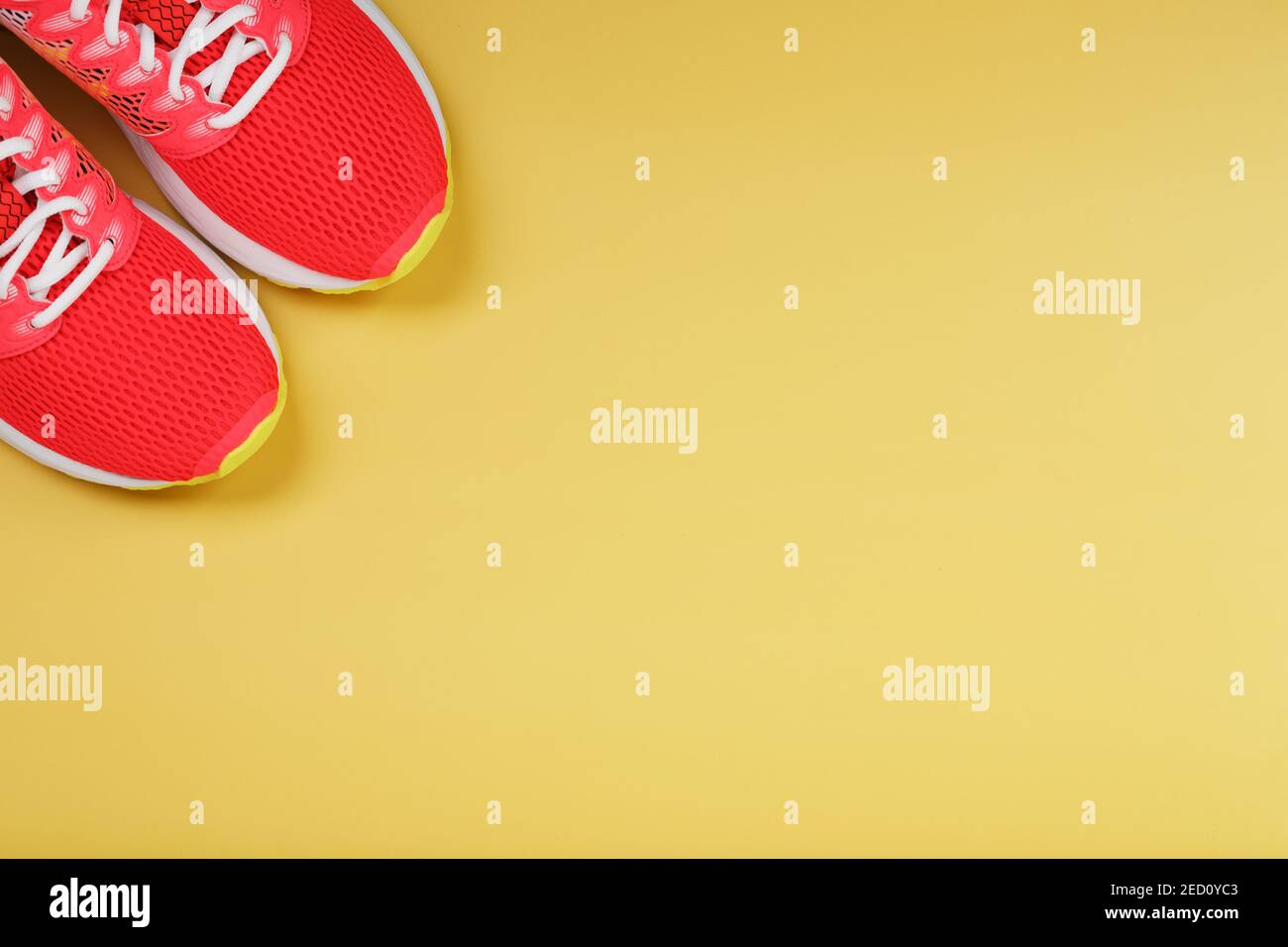 Sports sneakers, pink on a yellow background with free space. Top view ...