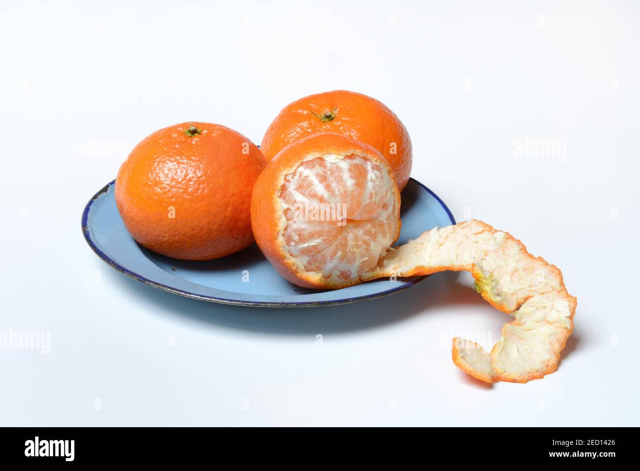 Clementines on plate, unpeeled and half peeled, white background, Germany Stock Photo Alamy