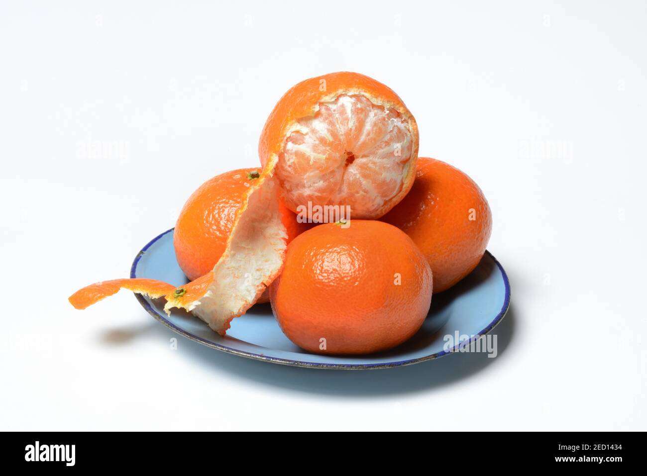 Clementines on plate, unpeeled and half peeled, white background, Germany Stock Photo Alamy
