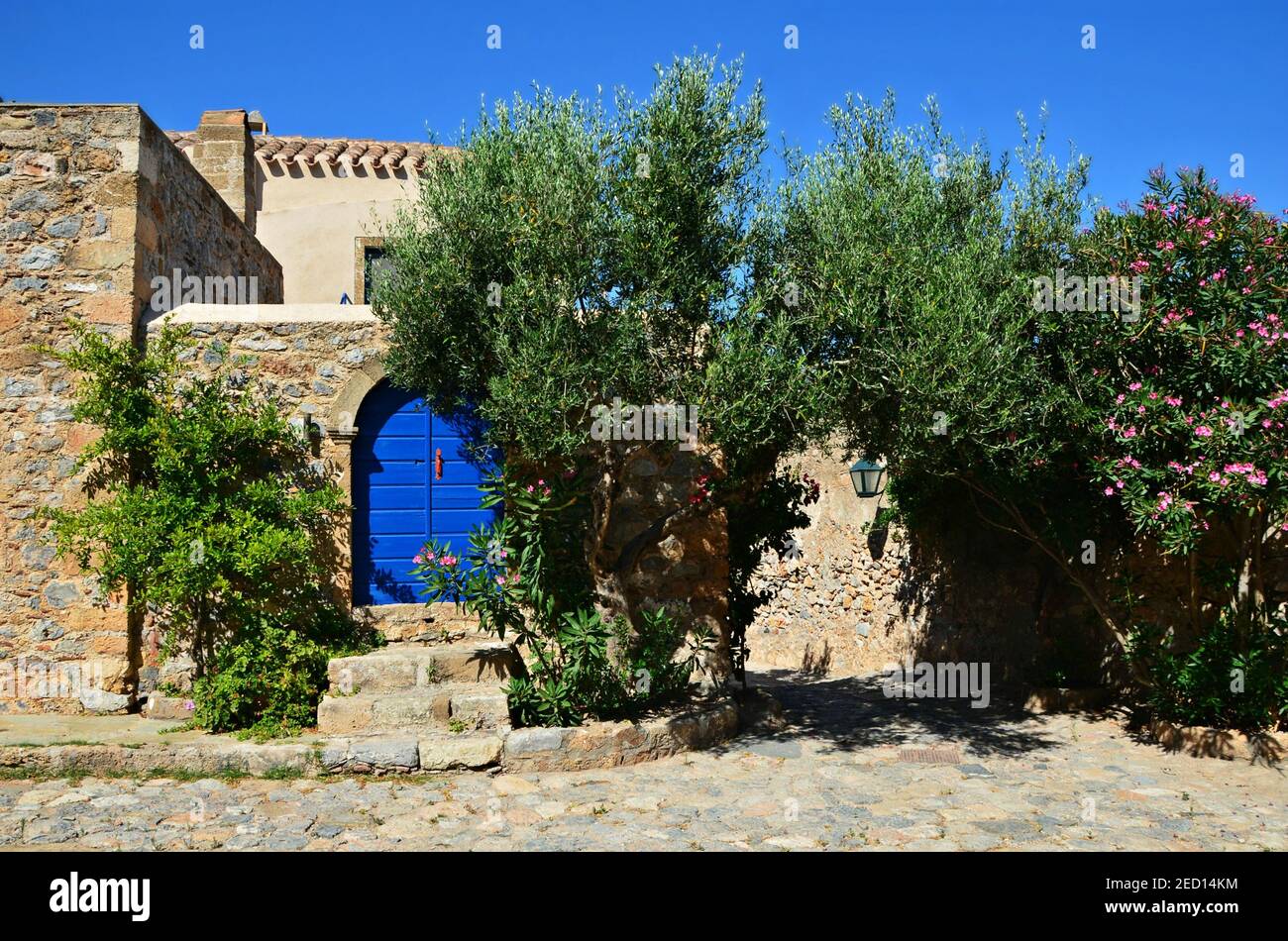 Traditional stone built rural house with a clay rooftop and a blue wooden  door in Spetses island, Attica Greece Stock Photo - Alamy