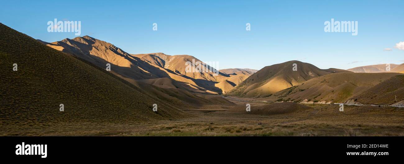 Barren mountain landscape with tufts of grass, Lindis Pass, Southern Alps, Otago, South Island, New Zealand Stock Photo