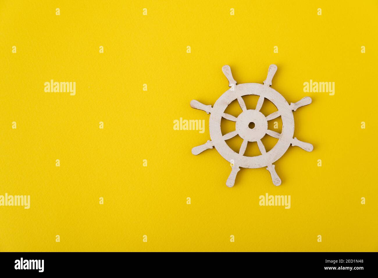 White steering wheel on yellow background. Marine theme. Yacht
