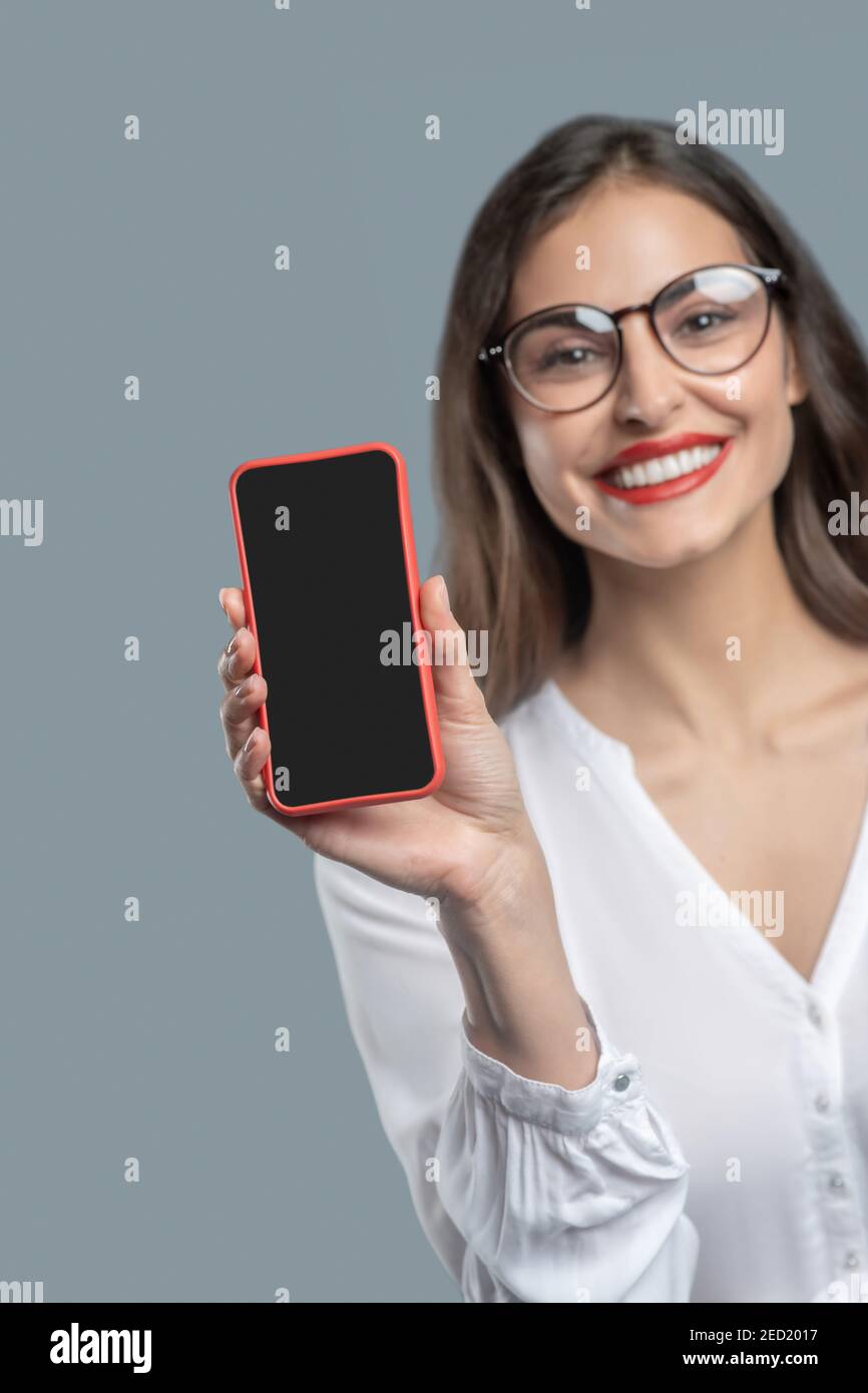 Joyful business woman in glasses showing smartphone Stock Photo
