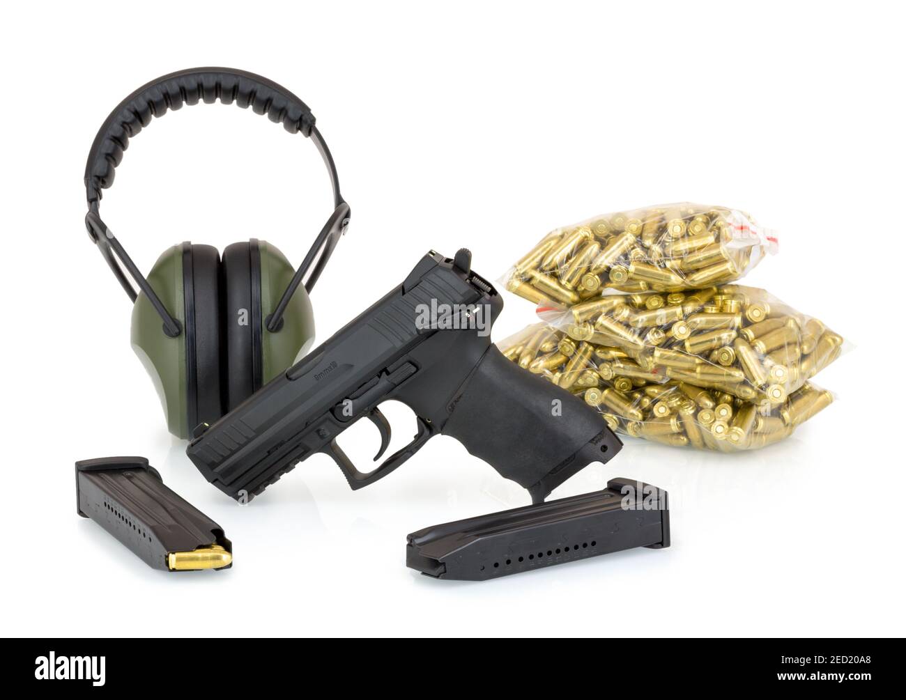 Pistol, ear protection and ammunition. Isolated on white background with shadow reflection. Gun, earmuffs, magazines and bullets 9mm stacked in bags o Stock Photo