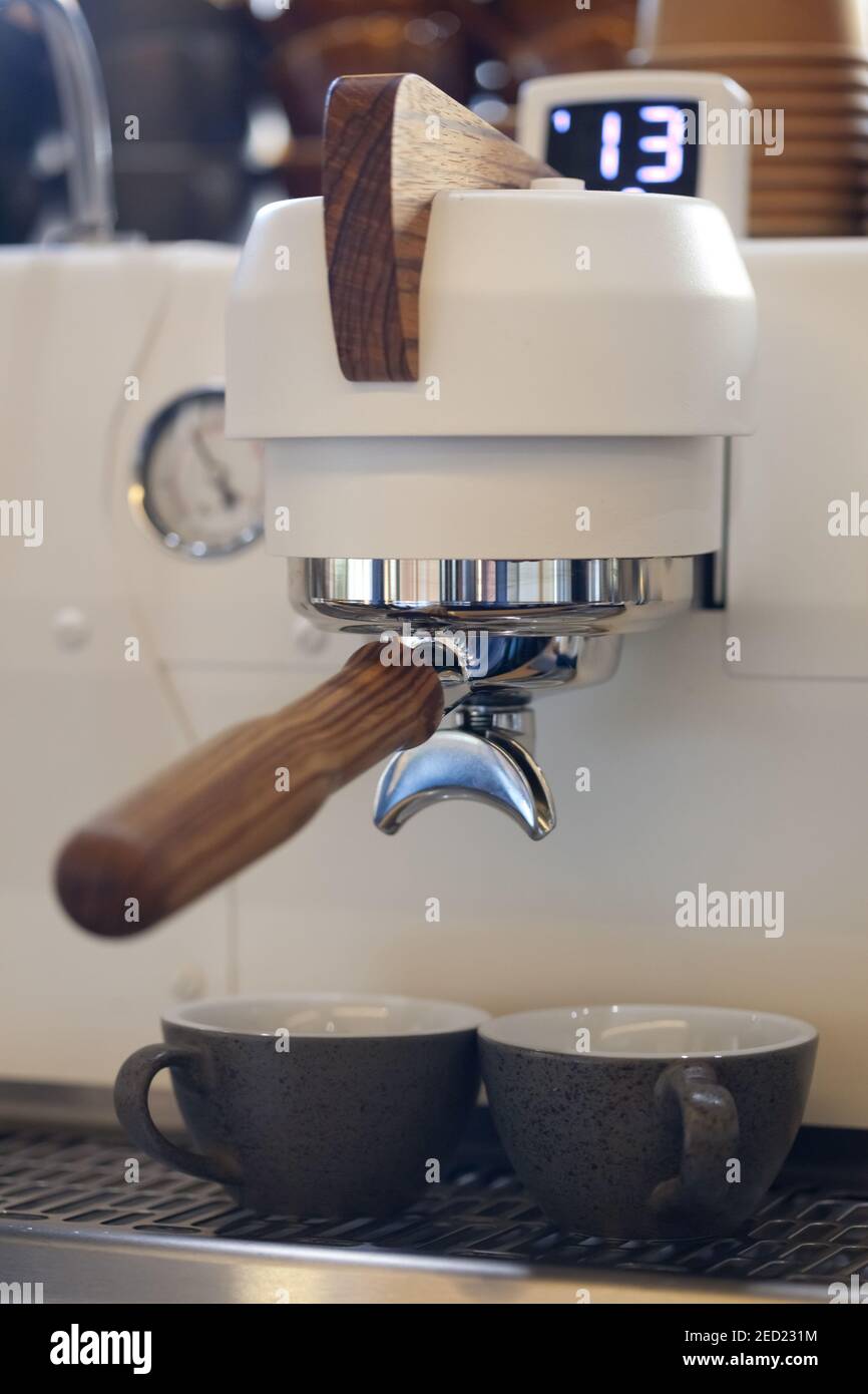 espresso ceramic cups in modern professional coffee machine, closeup, nobody Stock Photo