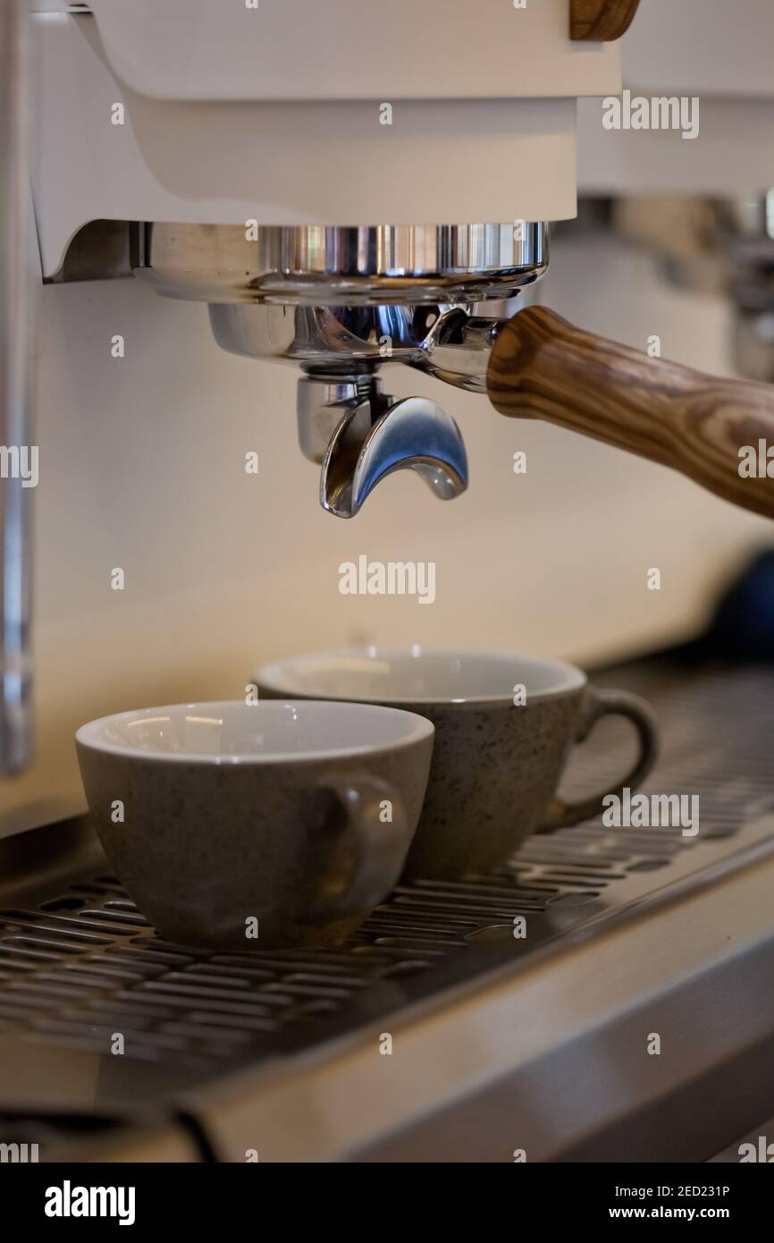 espresso ceramic cups in modern professional coffee machine, closeup, nobody Stock Photo