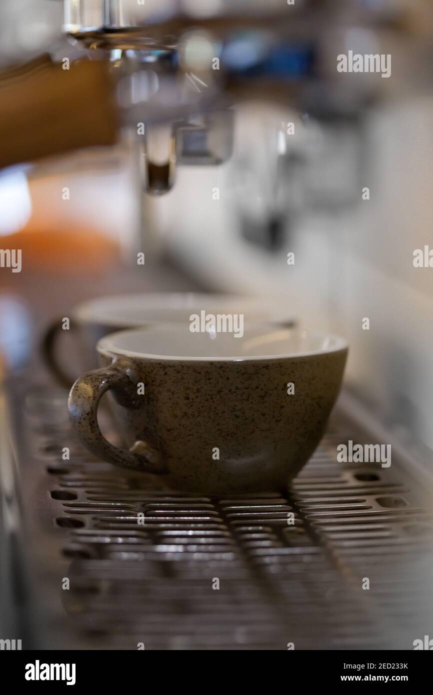 macro of espresso coffee cups in professional coffee machine with blurred backround, nobody Stock Photo