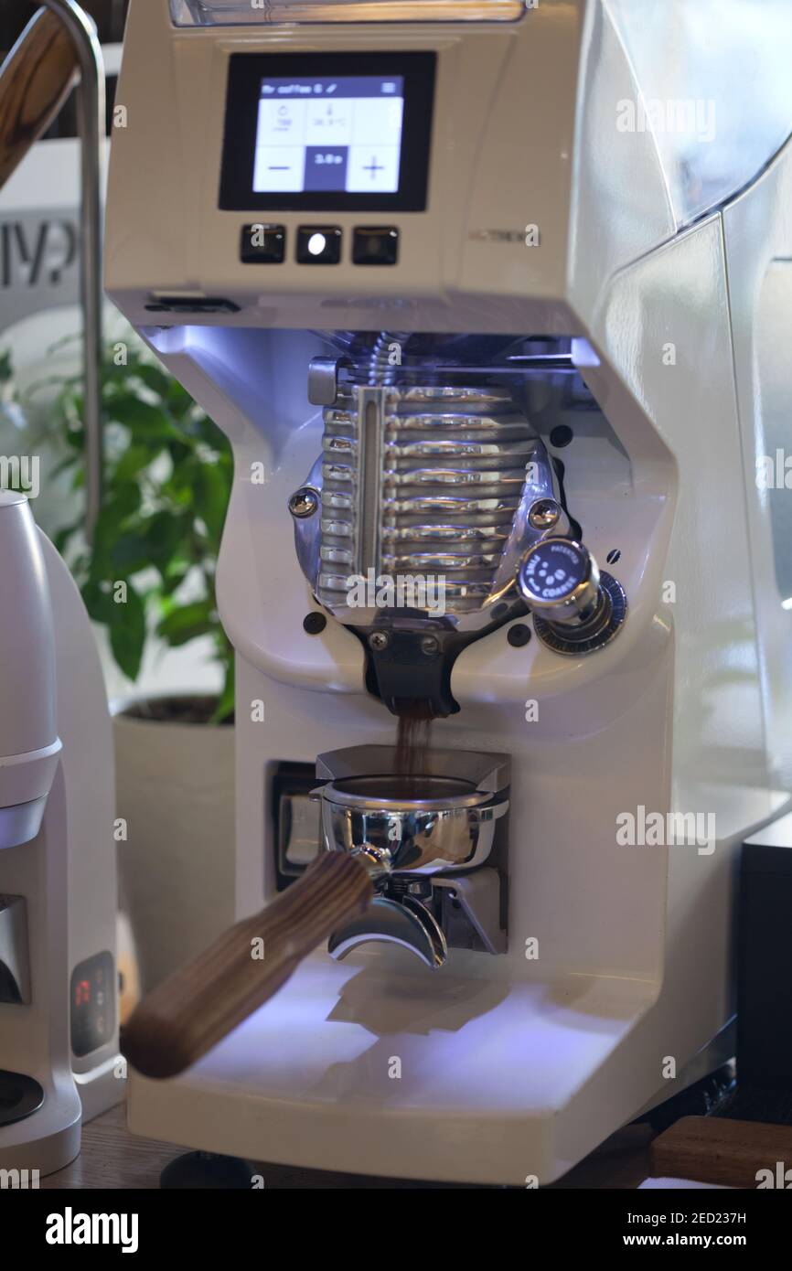 closeup of coffee being ground into holder in modern grinder, nobody Stock Photo