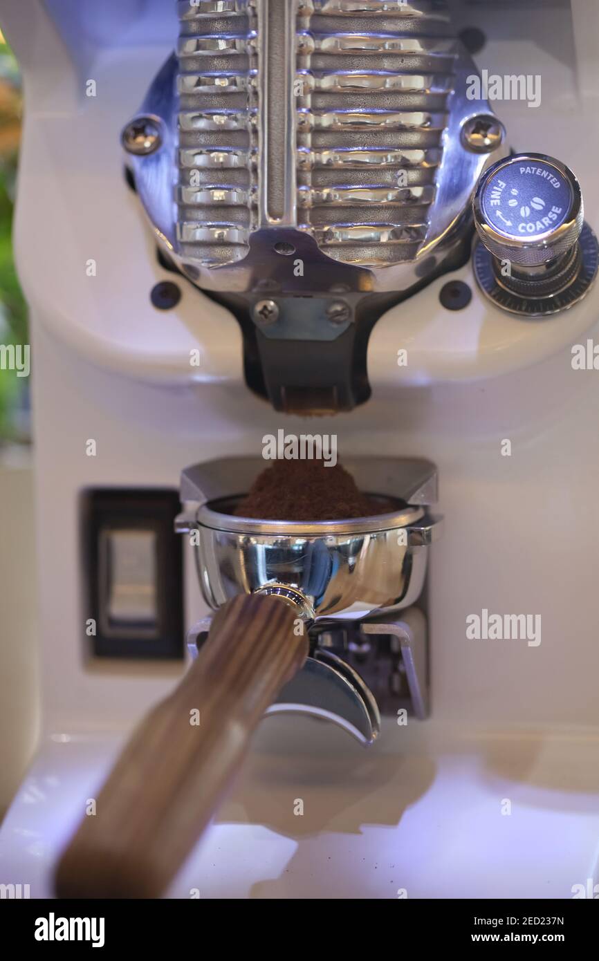 macro of ground coffee in espresso holder, modern grinder, closeup Stock Photo